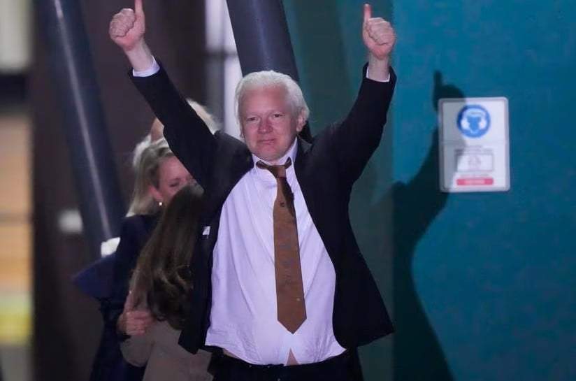 Julian Assange, fundador de WikiLeaks, hace un gesto con los brazos y los pulgares en alto tras aterrizar en la base de las Fuerzas Armadas Australianas en Fairbairn, Canberra