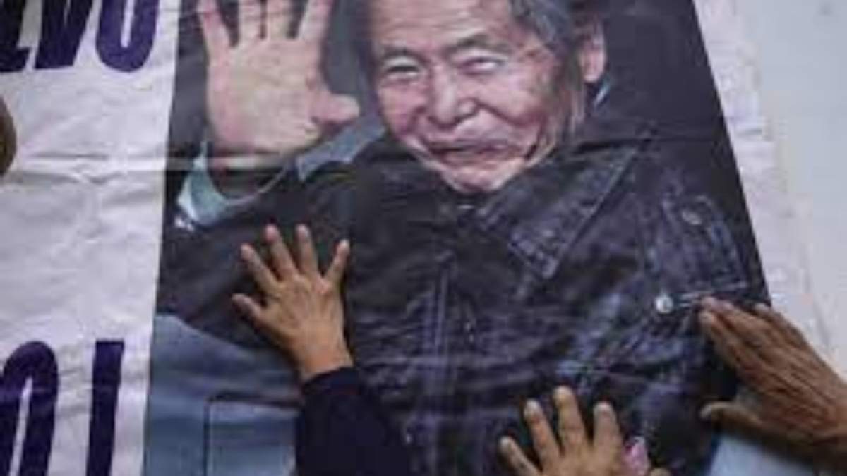 Los partidarios del expresidente encarcelado Alberto Fujimori tocan un cartel con su foto, afuera de la prisión donde está internado en las afueras de Lima, Perú