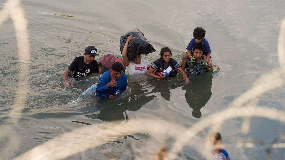 Un grupo de personas intena cruzar a Estados Unidos a través de río Grande, en México