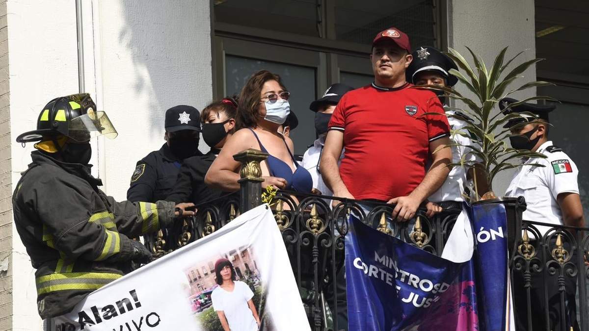 Silvia Castillo, cuyo hijo Alan fue asesinado, y Roberto Carlos Cuello, padre de una niña abusada sexualmente, permanecen en un balcón de la Secretaría de Gobernación