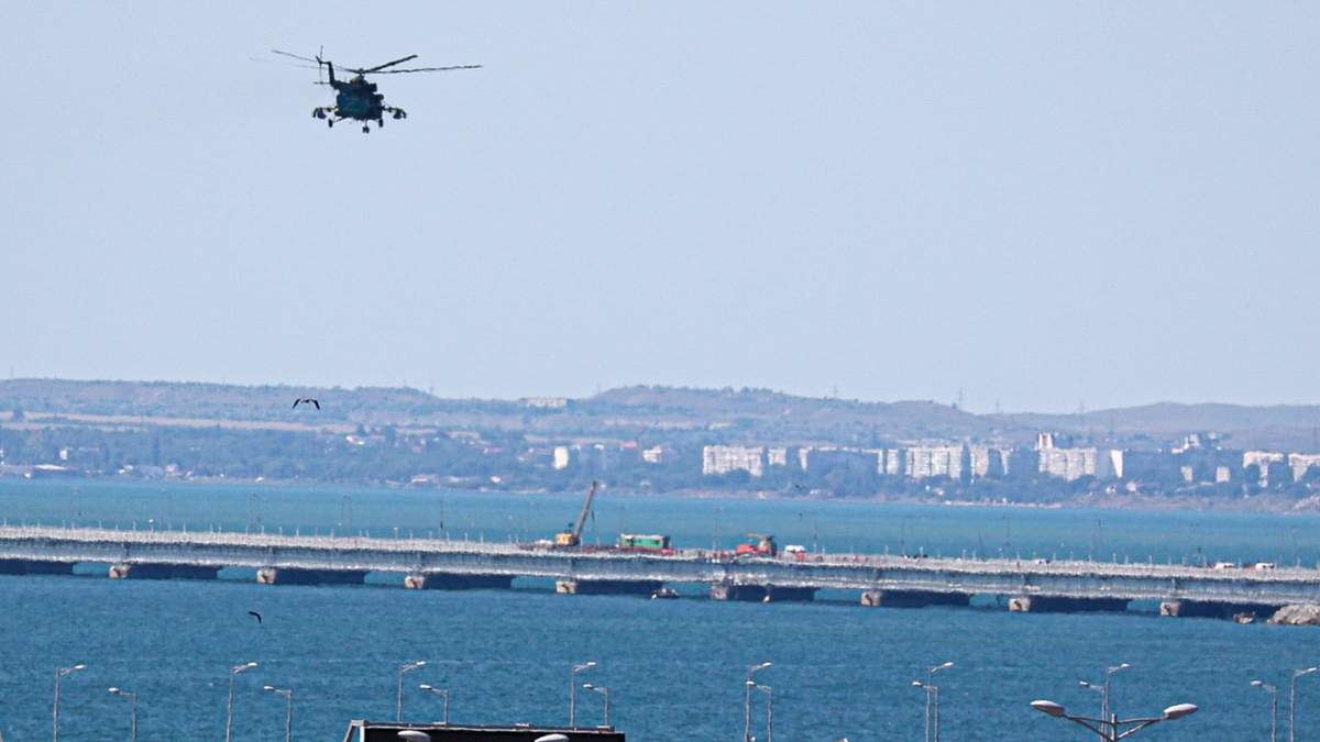Un helicóptero militar ruso vuela sobre partes dañadas del puente que conecta a Rusia con la península de Crimea sobre el Estrecho de Kerch