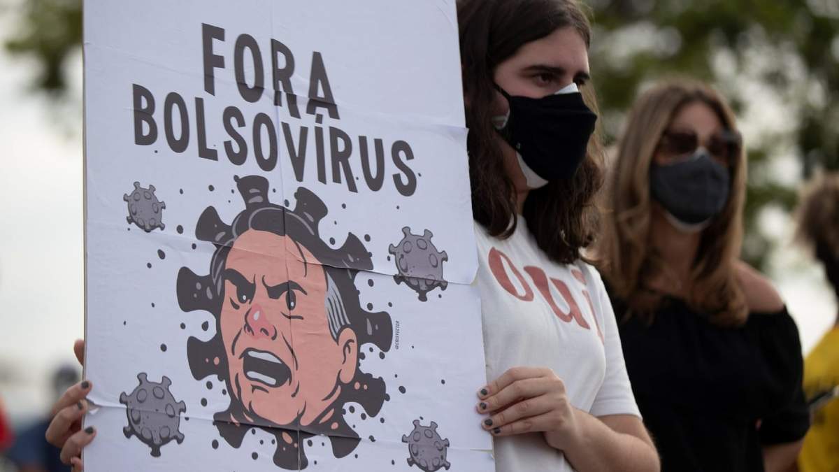 Una mujer sostiene una pancarta con la frase: "fuera bolsovirus", en Sao Paulo, Brasil. Fuente: (Twitter)
