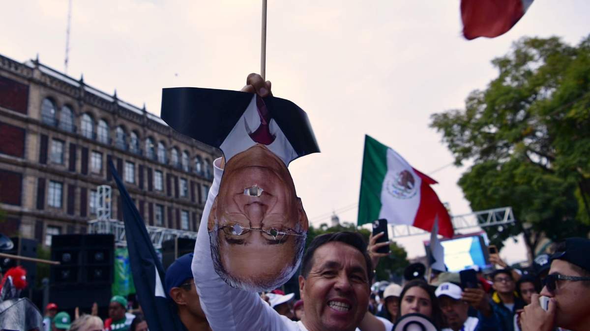 Un manifestante porta una imagen del ministro Pérez Dayan de cabeza