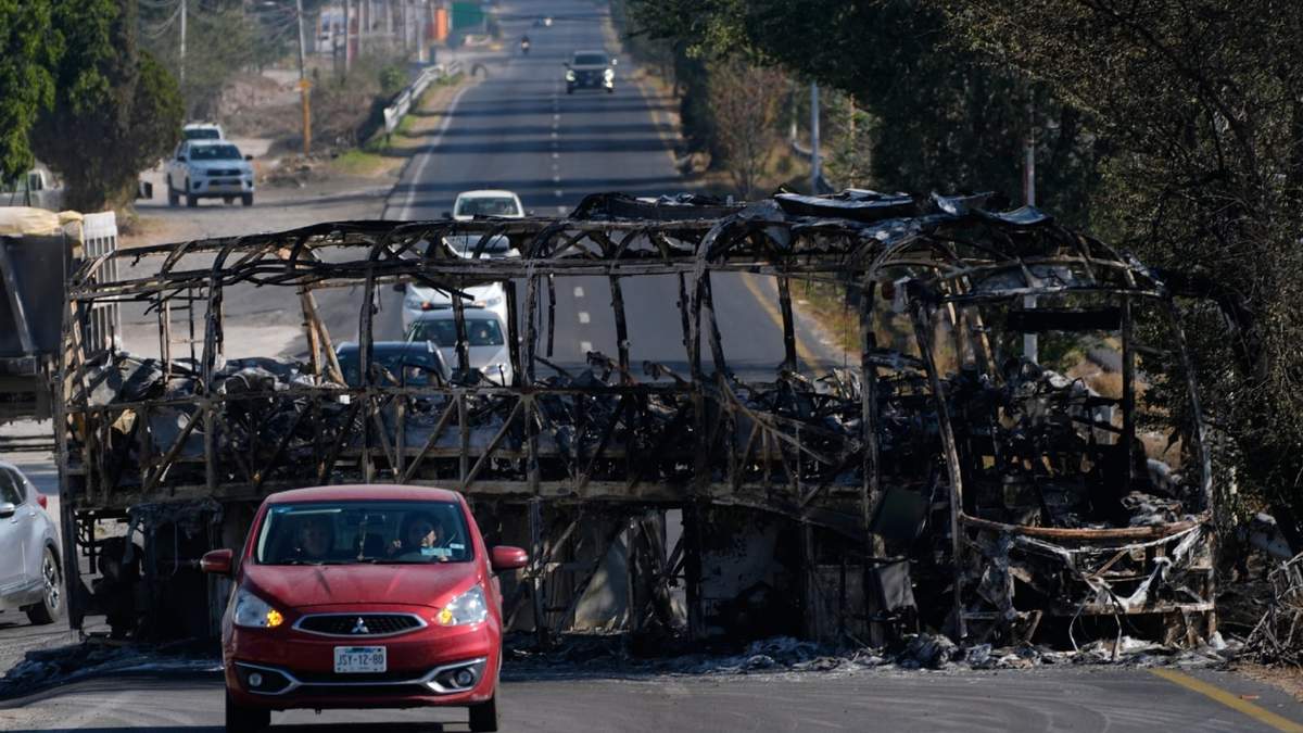 Vehículos pasan junto a un autobús quemado al día siguiente de que el ejército mexicano matara al líder del Cártel Jalisco Nueva Generación, Nemesio Oseguera Cervantes, conocido como "El Mencho", en Guadalajara, México, el lunes 23 de febrero de 2026