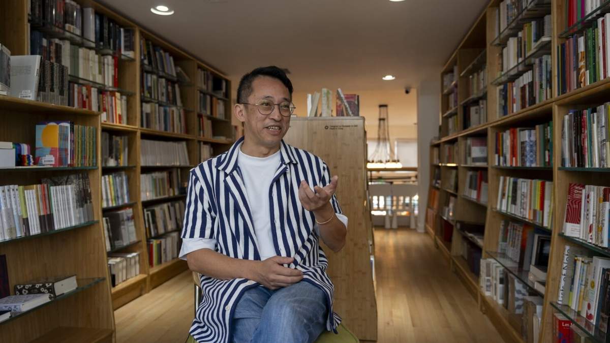 Yu Miao, propietario de JF Books, habla con The Associated Press en su librería de Washington