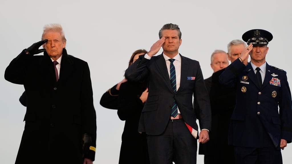 El presidente Donald Trump, el secretario de Defensa, Pete Hegseth, y el jefe del Estado Mayor Conjunto de la Fuerza Aérea, general Dan Caine (derecha), saludan mientras los equipos de transporte trasladan las cajas de transferencia con los restos de los soldados de la Guardia Nacional de Iowa, el sargento William Nathaniel Howard, de 29 años, de Marshalltown, Iowa, y el sargento Edgar Brian Torres-Tovar, de 25 años, de Des Moines, Iowa, y el intérprete civil Ayad Mansoor Sakat, quienes murieron en un ataque en Siria, durante un regreso de heridos, el miércoles 17 de diciembre de 2025 en la Base Aérea de Dover, Delaware