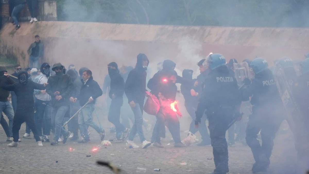 Hinchas de la Lazio se enfrentan con policías italianos con equipo antidisturbios fuera del estadio olímpico antes del inicio del partido de fútbol italiano entre la Lazio y la Roma en Roma, el domingo 13 de abril de 2025