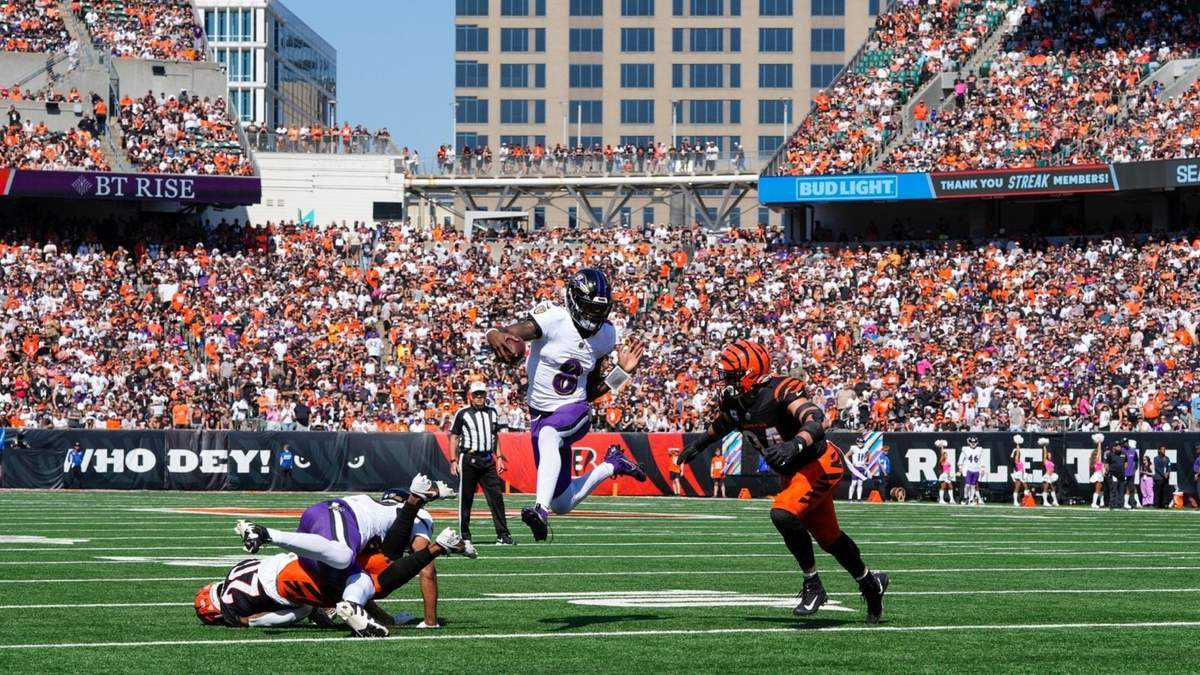 Lamar Jackson (8), quarterback de Ravens de Baltimore, corre con el balón mientras el defensive end Sam Hubbard (94), de los Bengals de Cincinnati, intenta darle alcance durante la primera mitad del juego de la NFL del domingo 6 de octubre de 2024, en Cincinnati