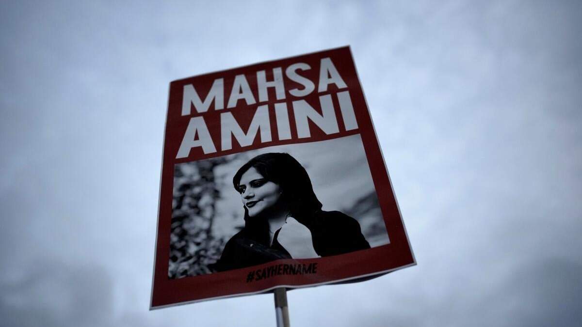 Una persona sostiene un cartel con una imagen de la iraní Mahsa Amini durante una protesta contra su muerte, en Berlín, Alemania