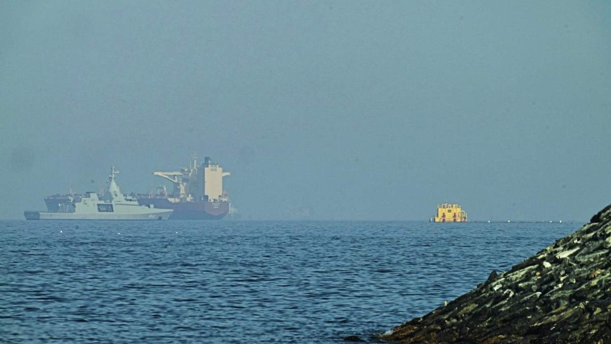 Una patrullera emiratí (izquieda), navega cerca de un petrolero fondeado en el golfo de Omán, cerca del estrecho de Ormuz, vistos desde una carretera costera cerca de Khor Fakkan, Emiratos Árabes Unidos, el 1 de mayo de 2026