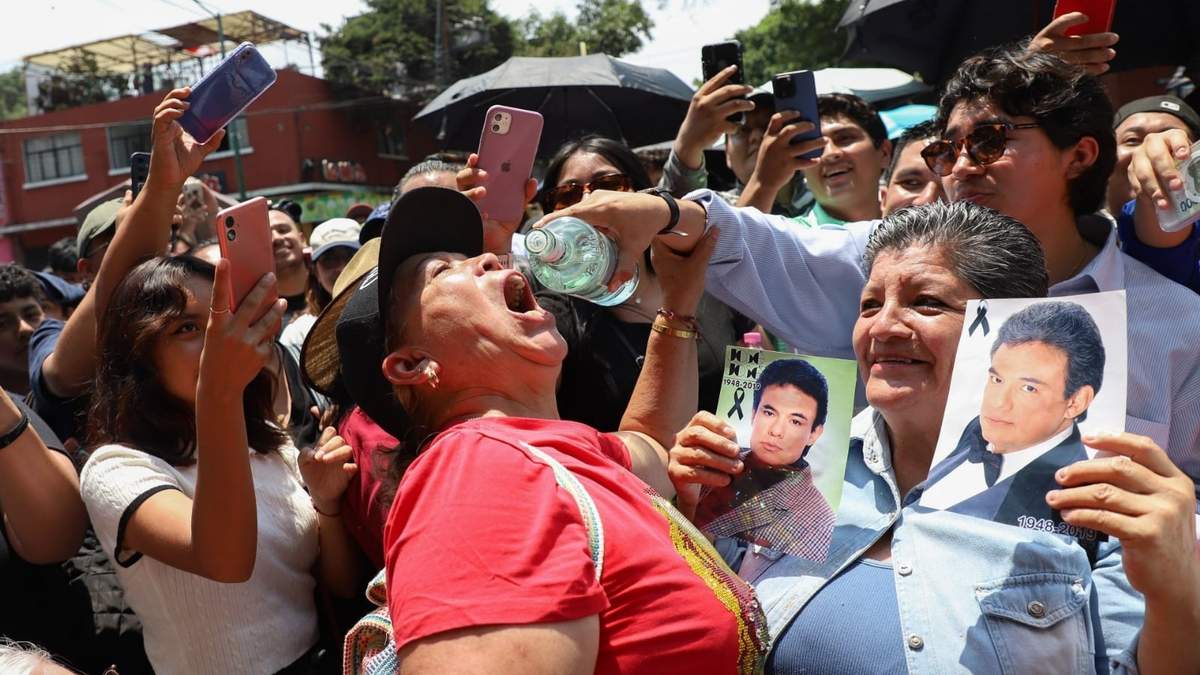 Una persona bebe ron que era repartido por los seguidores de José José, durante el homenaje que le realizaron este domingo