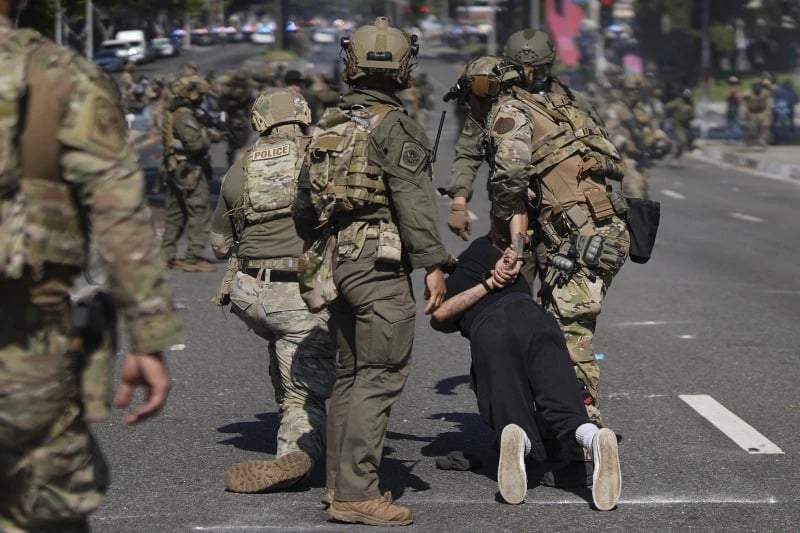 La policía detiene a un hombre durante una protesta en el barrio Paramount de Los Ángeles, el sábado 7 de junio de 2025, tras operativos de las autoridades federales de inmigración.