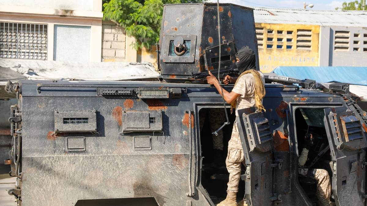 La policía se cobija durante una operación antipandillas en Puerto Príncipe, Haití, el viernes 1 de marzo de 2024