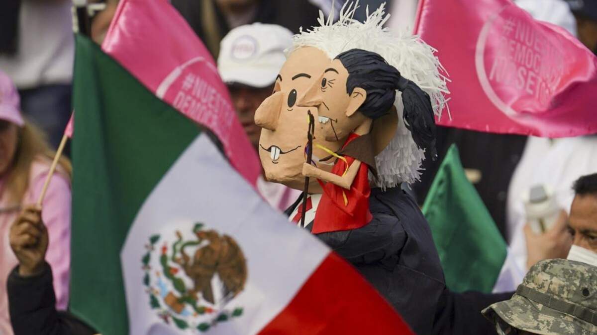 Manifestantes portan muñecos con la imagen del presidente de México, Andrés Manuel López Obrador, y de la candidata presidencial, Claudia Sheinbaum