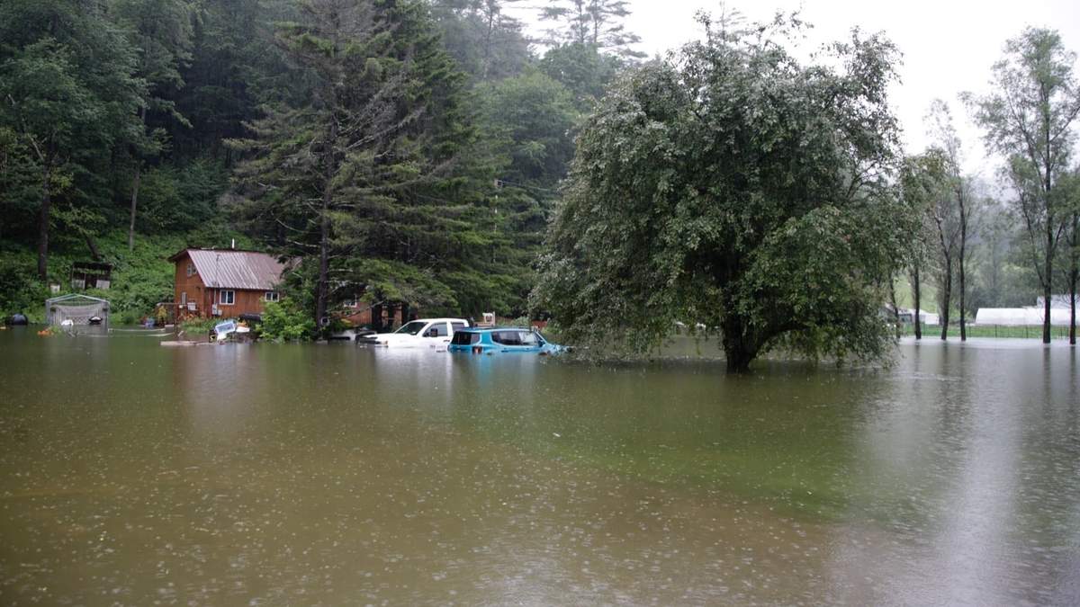 Vehículos sumergidos y residencias en riesgo por las inundaciones cerca del río Ottauquechee en Bridgewater, Vermont.