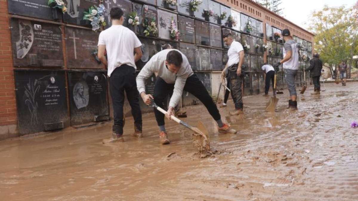 Gente retira lodo de un cementerio dañado por inundaciones a las afueras de Valencia, España, después de inundaciones en la región