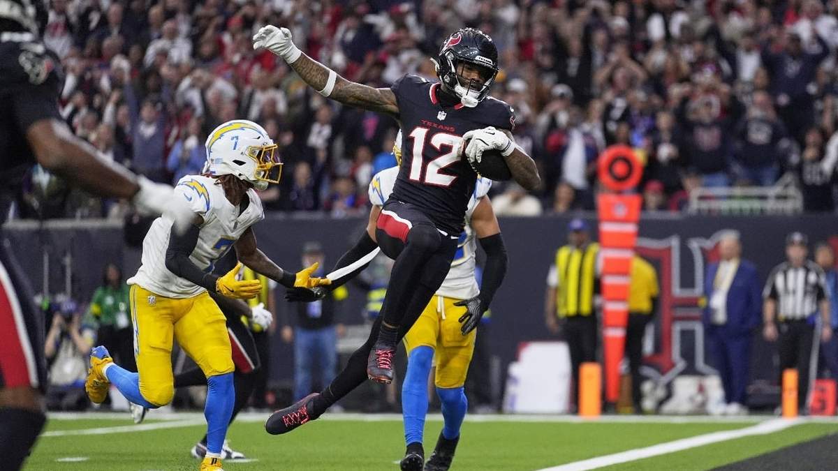 Nico Collins, wide receiver de los Texans de Houston, salta a la zona de anotación para un touchdown después de atrapar un pase mientras Kristian Fulton, de los Chargers de Los Ángeles, en la primera mitad de la ronda de comodines de la NFL
