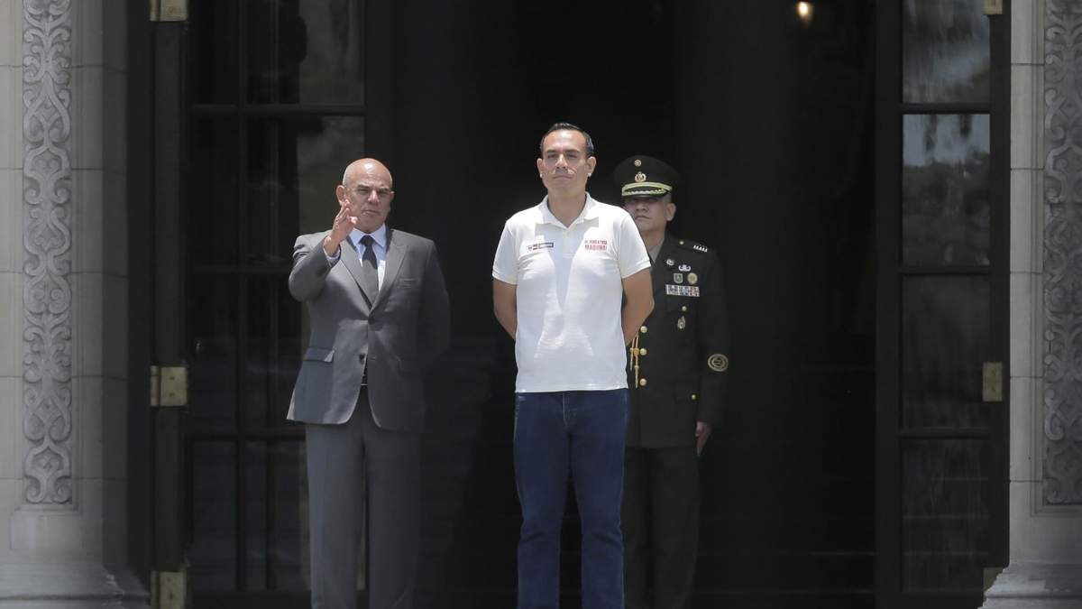 El presidente interino de Perú, José Jeri, a la derecha, es fotografiado a través de una puerta junto al primer ministro Ernesto Álvarez durante la ceremonia de cambio de guardia en el palacio de gobierno en Lima