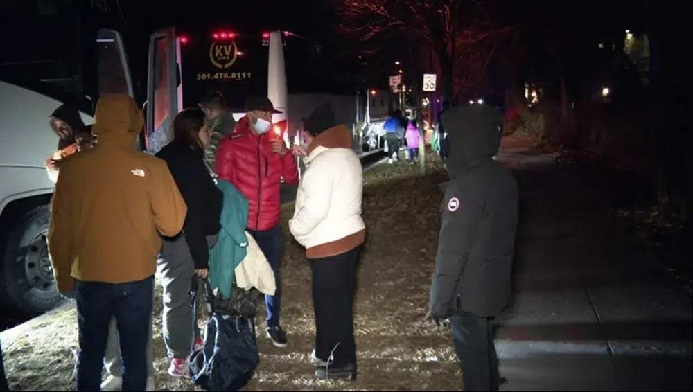 Migrantes suben a un autobús en los alrededores de la residencia de la vicepresidenta Kamala Harris para ir a una iglesia del área
