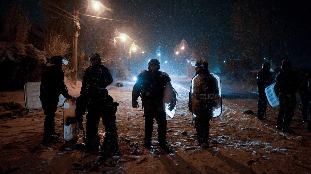 La policía hace guardia en una calle cerca de un supermercado tras los reportes de saqueadores que intentaban acceder al local en Bariloche, Argentina, el miércoles 23 de agosto de 2023
