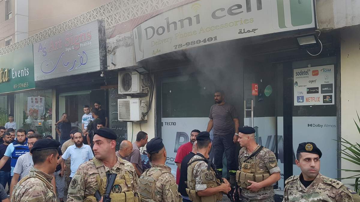 Soldados libaneses se congregan afuera de una tienda de celulares dañada luego de lo que se cree que fue el resultado de una explosión de walkie-talkie en su interior, en Sidon, Líbano