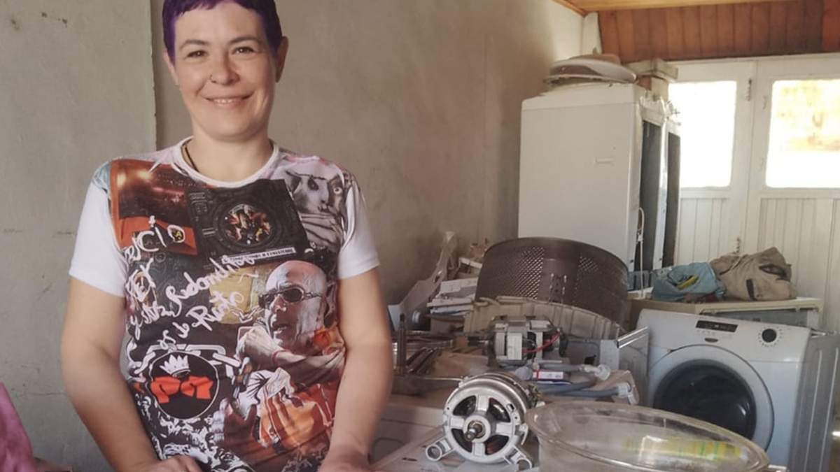 Laura Hernández rodeada de lavarropas desarmados. Fuente: (Miguel Ángel Parra)