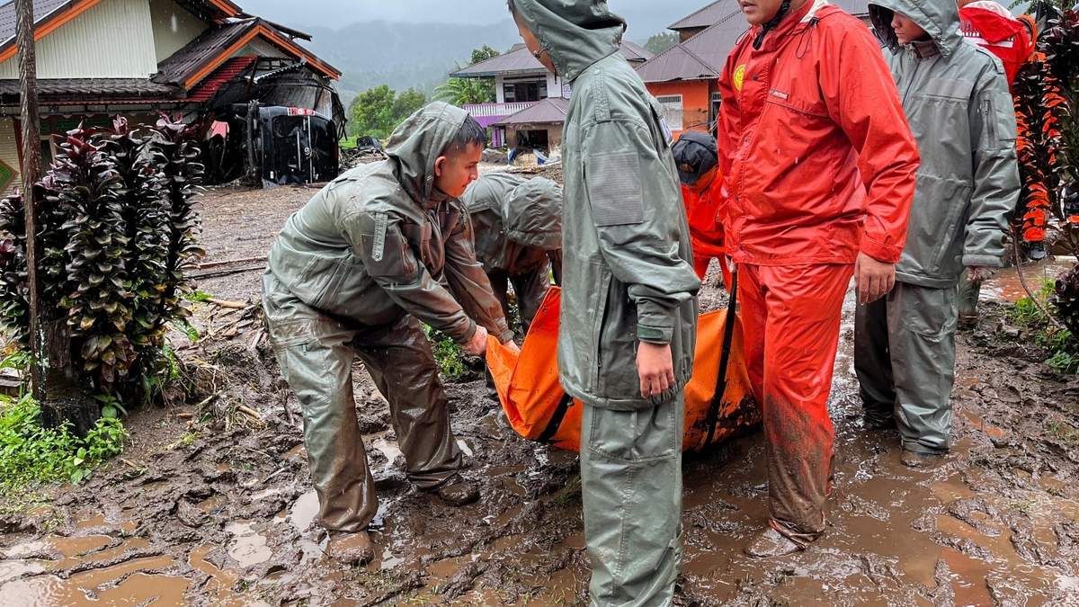 Rescatistas cargan el cuerpo de una víctima de las inundaciones en Malalak, Sumatra Occidental, Indonesia