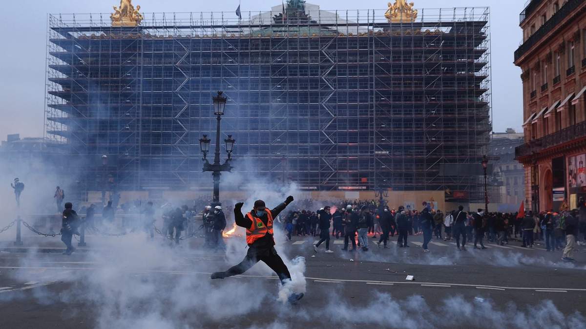 Un manifestante patea una lata de gas lacrimógeno durante una manifestación en París