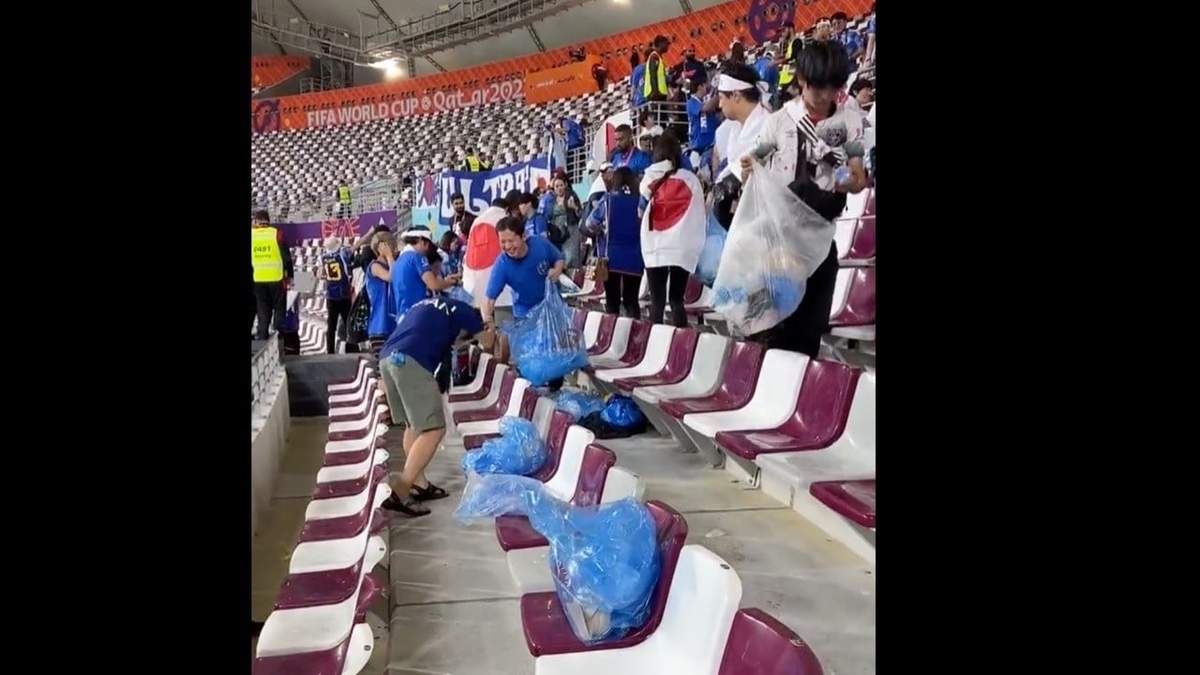 Japoneses recogen la basura en las gradas del estadio Khalifa, luego del encuentro donde su selección venció a Alemania