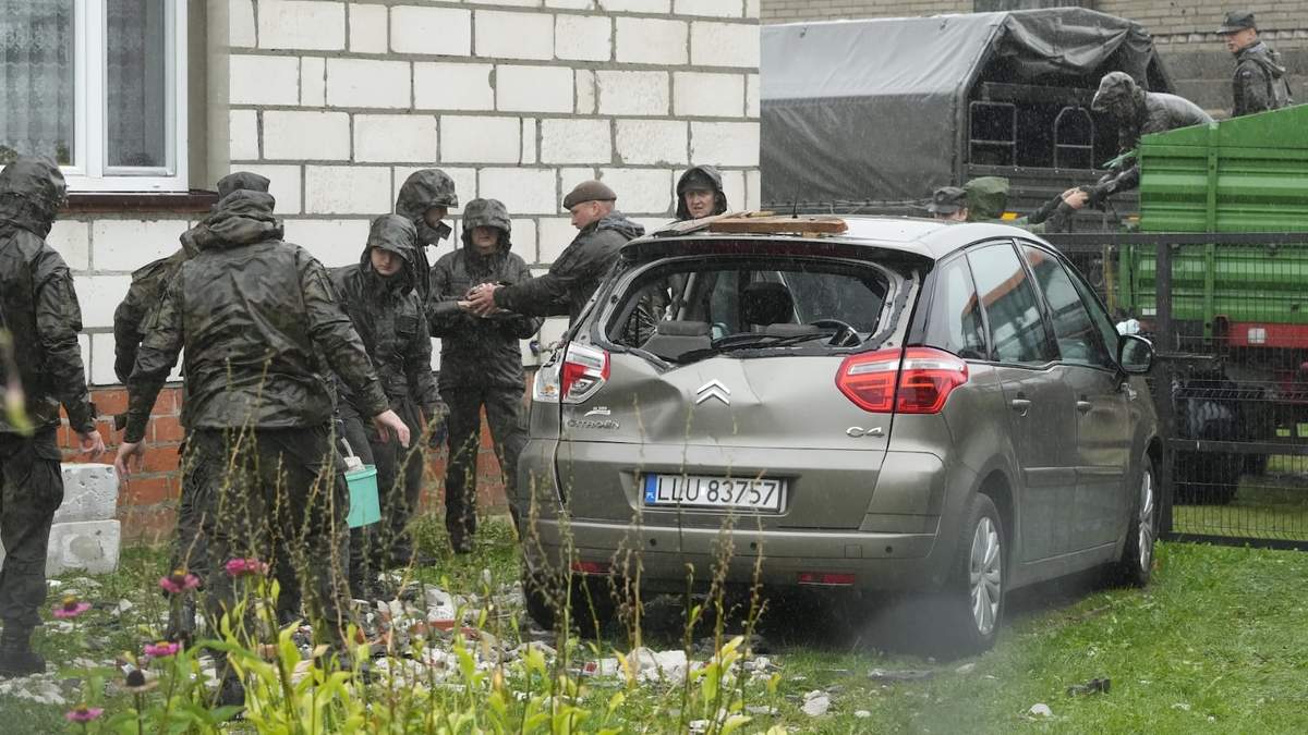 Agentes de defensa territorial retiran los restos del techo destruido de una vivienda, después de que drones rusos violara el espacio aéreo de Polonia en un ataque contra Ucrania el jueves