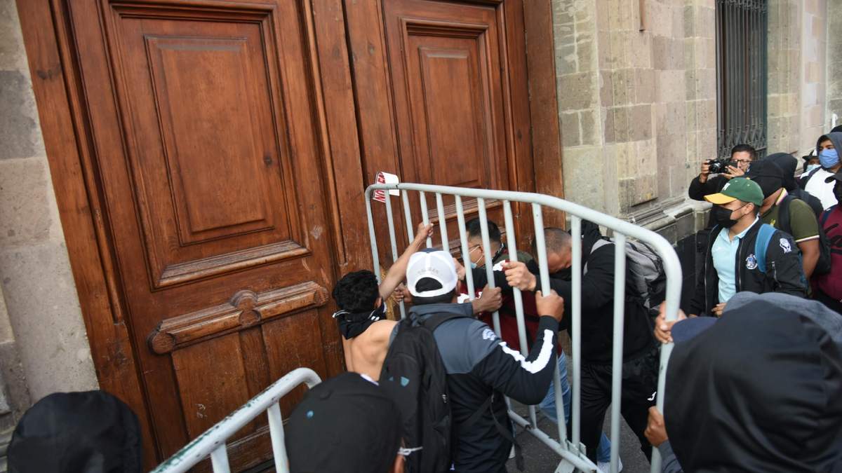 Estudiantes de la Escuela Normal Rural "Raúl Isidro Burgos" intentaron derribar con una valla metálica  una puerta en Palacio Nacional, ubicada en la calle de Moneda.
