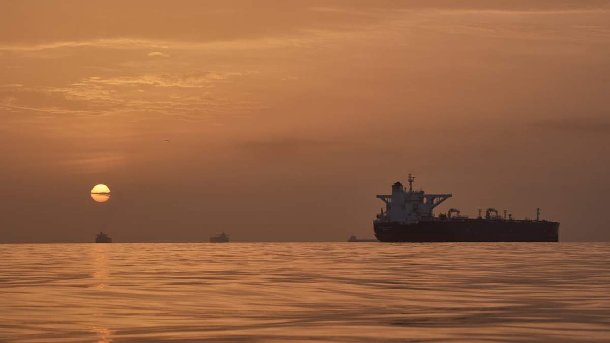 El sol sale tras varios petroleros fondeados en el estrecho de Ormuz en la costa de la isla de Queshm, Irán, el sábado 18 de abril de 2026