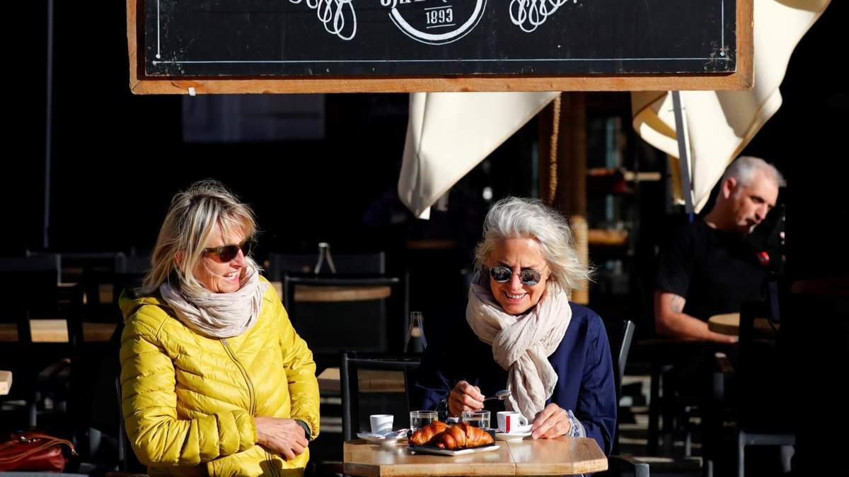 Dos mujeres toman café al aire libre en París, capital de Francia. Fuente: (Twitter)