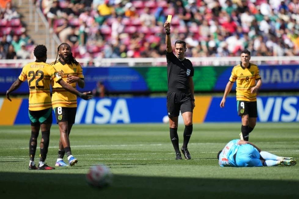 El árbitro Facundo Tello muestra una tarjeta amarilla a Ronaldo Webster (22) de Jamaica durante la final de la repesca para la Copa Mundial entre la República Democrática del Congo y Jamaica en Guadalajara, México, el martes 31 de marzo de 2026.