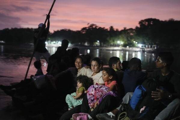 La migrante venezolana Lisbeth Contreras abraza a sus hijos mientras cruzan el río Suchiate, fronterizo entre Guatemala y México, desde Tecún Umán, Guatemala rumbo a EU