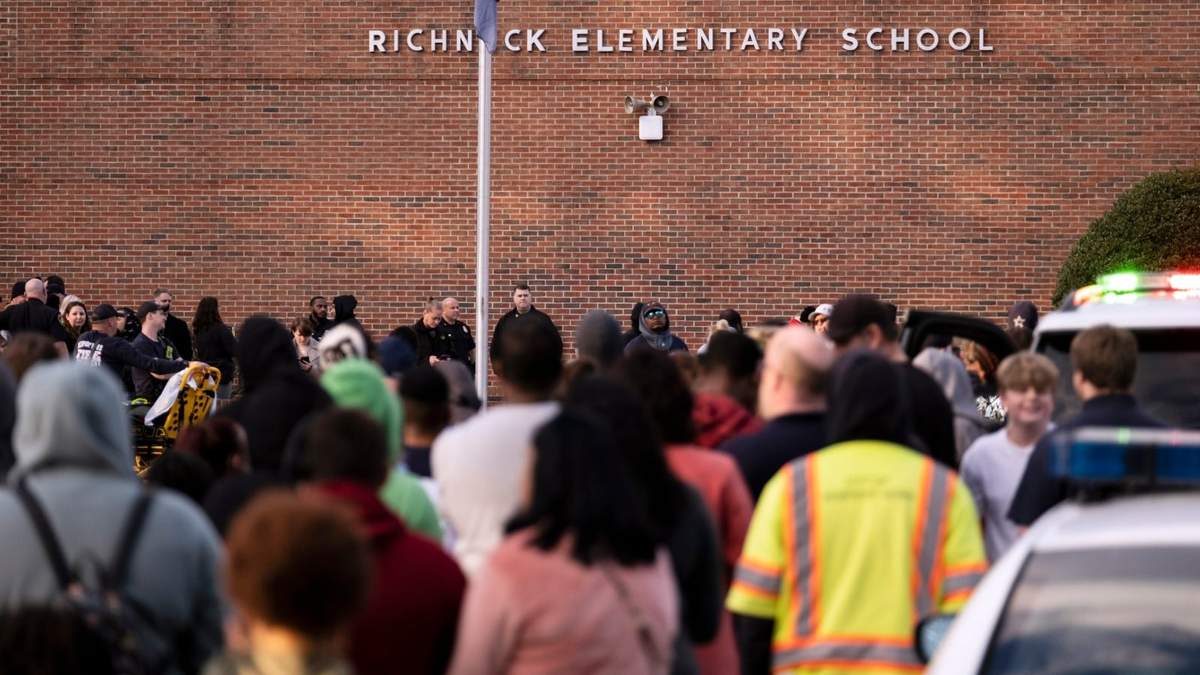 Estudiantes y agentes de la policía se reúnen afuera de la Escuela Primaria Richneck en Newport News, Virginia