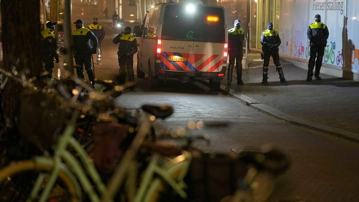 Policías vigilan una protesta de opositores a las restricciones por el covid-19 en La Haya, Países Bajos