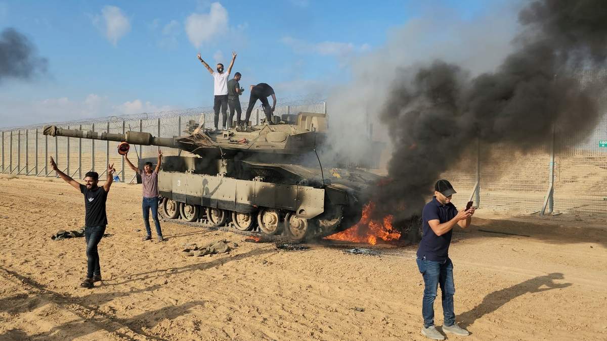 Palestinos celebran junto a un tanque israelí destruido en la valla de la Franja de Gaza al este de Khan Younis