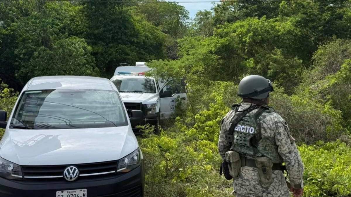 Autoridades resguardan el área donde fueron hallados los cuerpos de tres taxistas asesinados, en la carretera federal 307