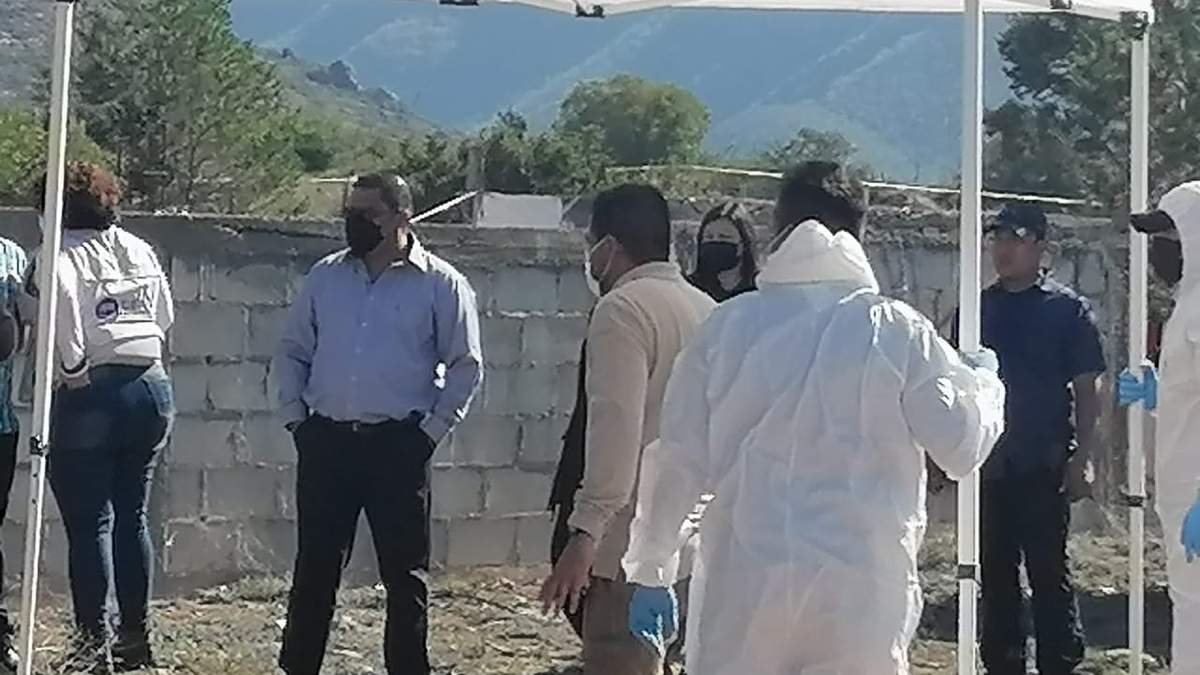 Mario Escobar al lado de personal que llevó a cabo la exhumación