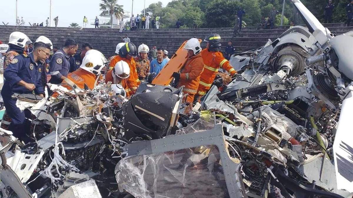 En esta imagen, distribuida por el Departamento de Bomberos y Rescate de Malasia, varios operarios inspeccionan el lugar donde se estrellaron dos helicópteros militares, en Lumur, en el estado de Perak