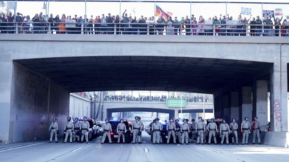 Personal policial frente a un grupo de manifestantes que cerraron la circulación en la autopista 110 durante una protesta para exigir una reforma de inmigración