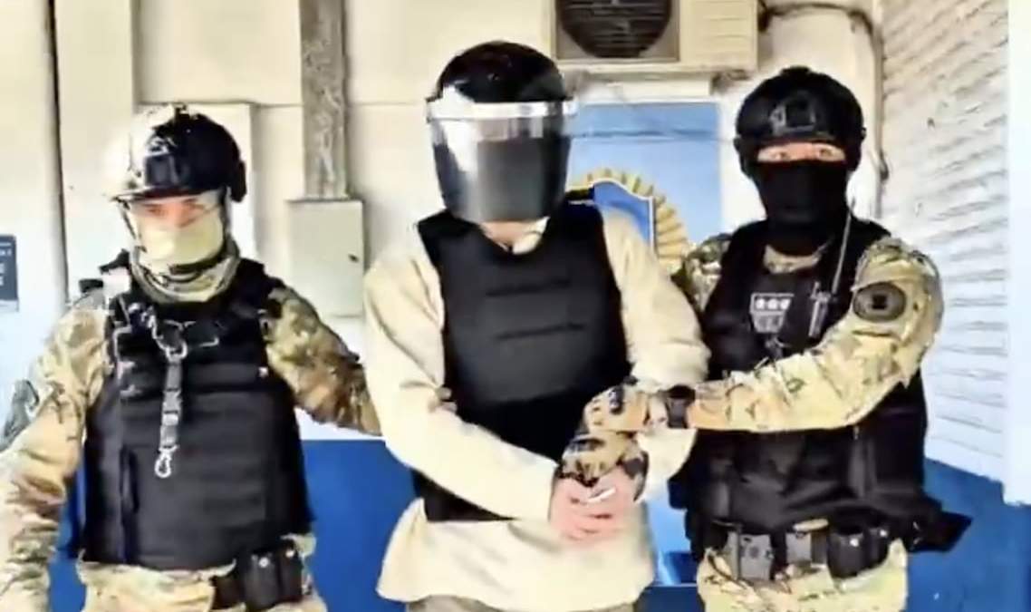 El contralmirante (centro) con su uniforme de reo