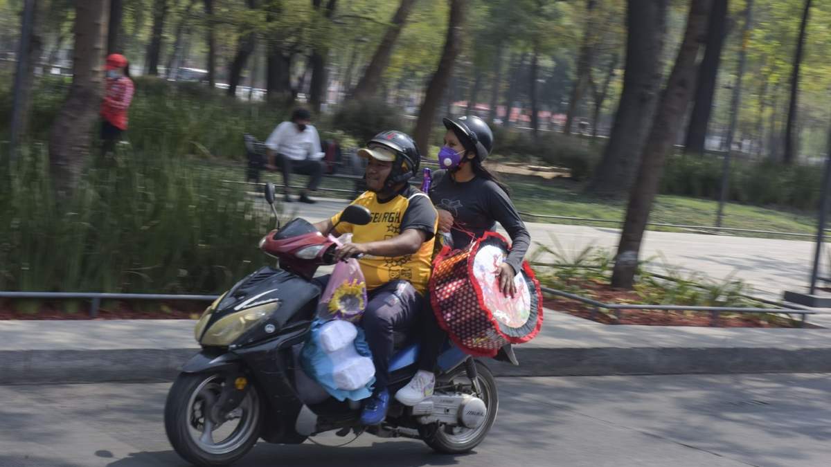 Una pareja abordo de una moto recorre Avenida Juárez