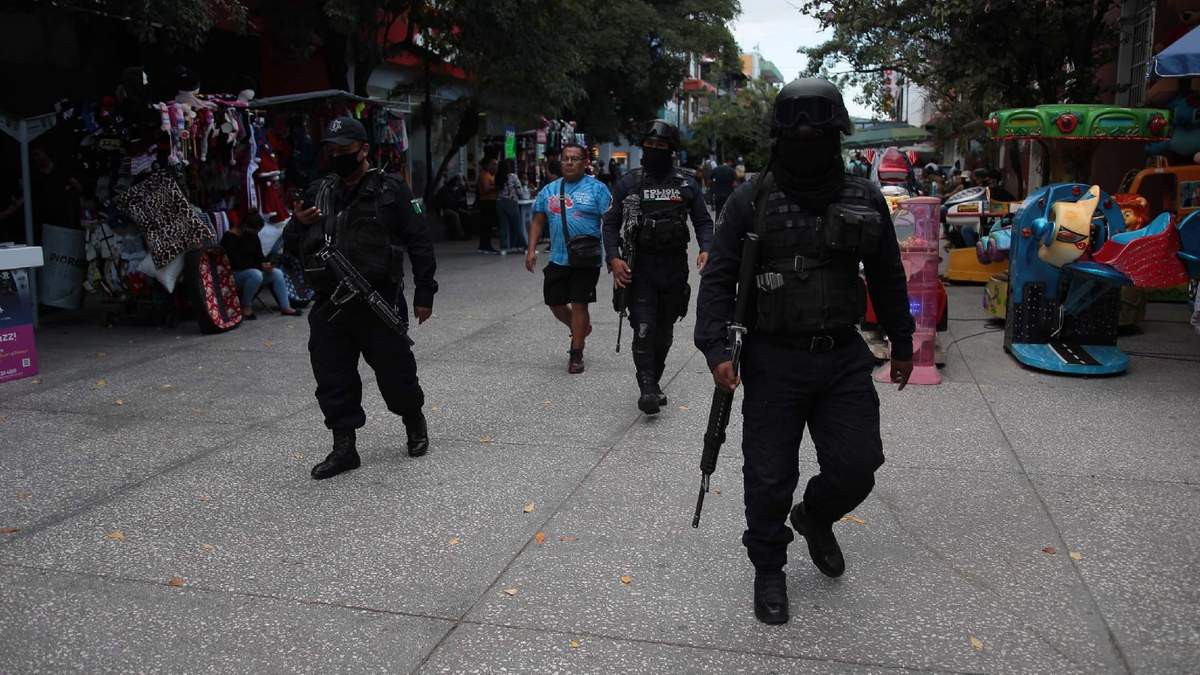 Elementos de la policía estatal y de la Guardia Nacional resguardan las inmediaciones de un banco