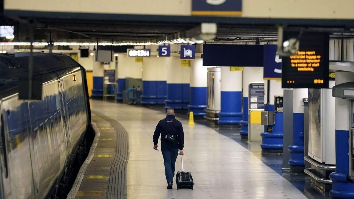 Un pasajero camina por la estación Euston durante una huelga de servicio de trenes en demanda de mayores salarios, en Londres