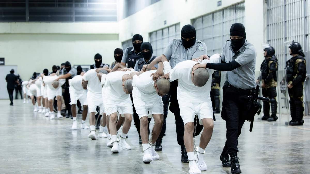 Guardias penitenciarios trasladan a presuntos pandilleros venezolanos, deportados de Estados Unidos, al Centro de Confinamiento del Terrorismo (CECOT), en Tecoluca