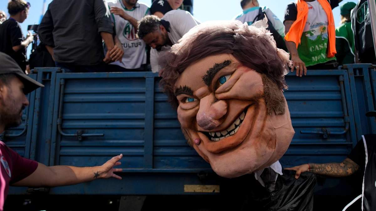 Un manifestante sostiene un muñeco gigante que representa al presidente Javier Milei