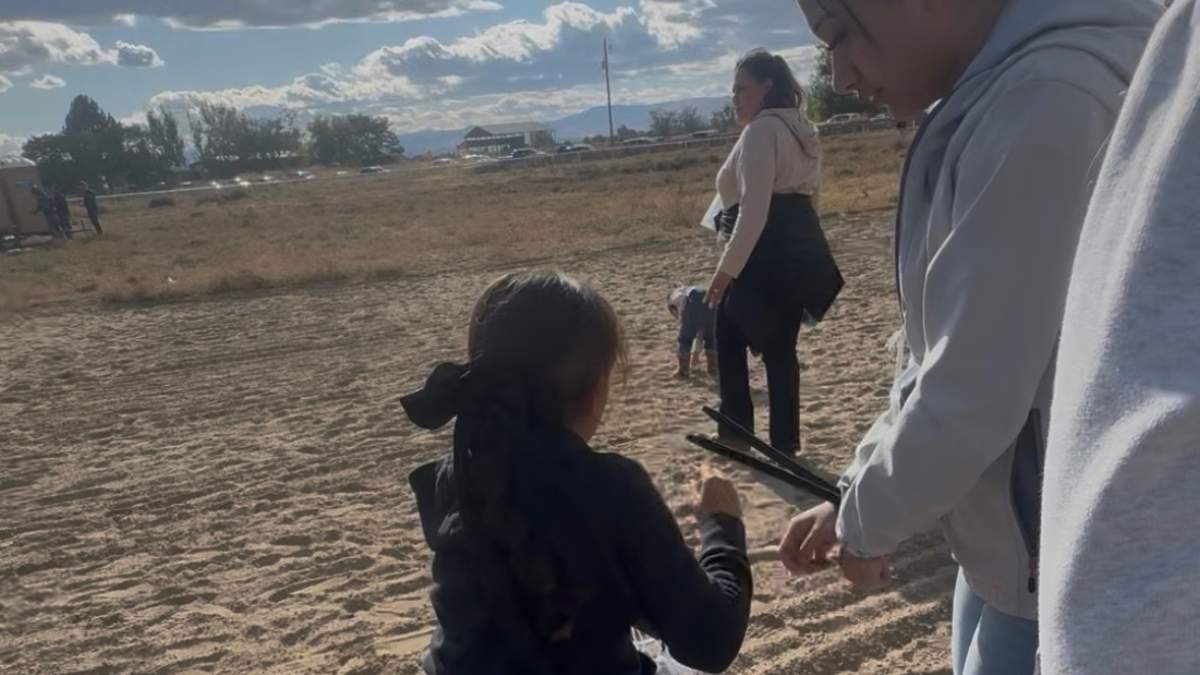 En la imagen, proporcionada por Anabel Romero, aparece su hija de 14 años, derecha, con las manos atadas con bridas, junto a su hija de 8 años, al frente, centro, durante una redada efectuada por varias agencias del orden en el hipódromo La Catedral Arena en Wilder, Idaho, el 19 de octubre de 2025