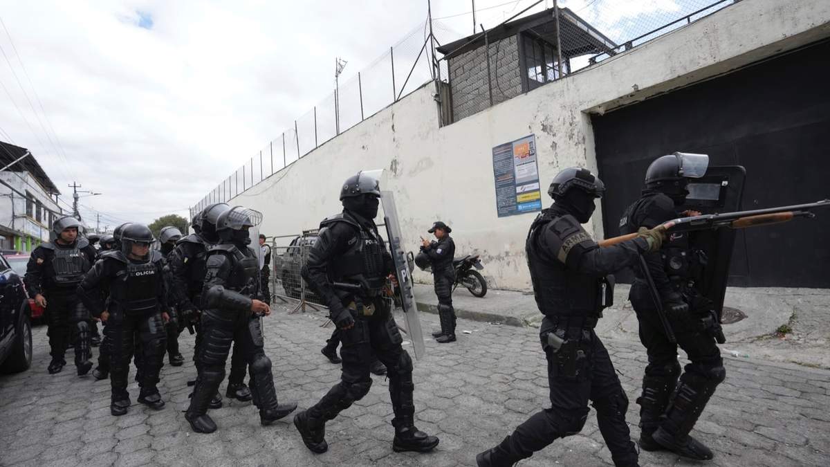 Policías y soldados se preparan para ingresar a la prisión El Inca donde se registran disturbios, en Quito